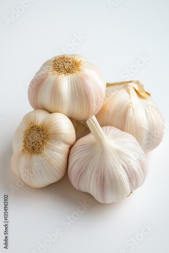 A bunch of garlic bulbs are piled on top of each other. The bulbs are white and pink, and they are all different sizes. Concept of abundance and variety, as the garlic bulbs come in different shapes