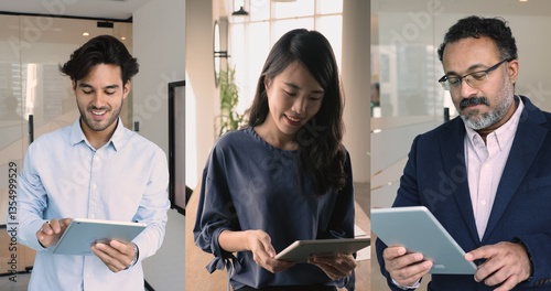 Three multinational teammates, business professionals standing in office holding modern tablets devices, checking e-mails, correspond to clients, using corporate platforms. Digital tools, trading, AI