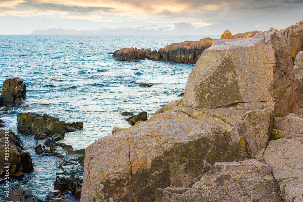 sea rock on the coast. rough surface. travel nature background with stone on the shore. beautiful summer vacation at the seaside. calm surface of blue water and evening sky in seascape