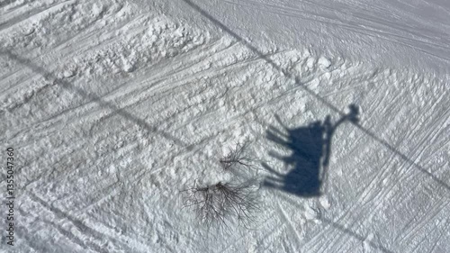 Shadow of a skiers going up in a ski lift in a ski resort in French alps.