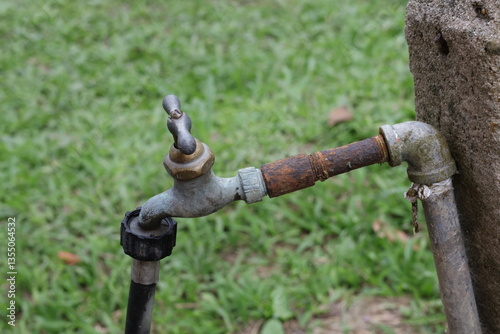 Fotografie Una toma de cerca de  una tubería vieja con una llave de agua para regar el jard