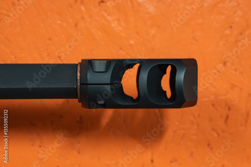 Quadro su tela Large muzzle brake compensator on the rifle barrel on orange background