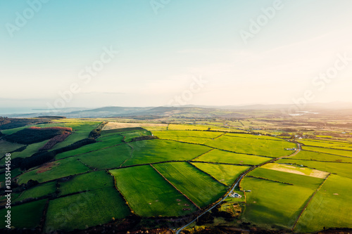 Aerial View of Scenic Green Fields and Countryside Road in Wicklow, Ireland at Sunset