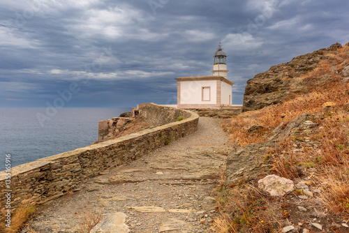 Obraz na płótnie Coastal view of Far de Cala Nans lighthouse near Cadaques in Catalonia, Spain under cloudy skies w salonie
