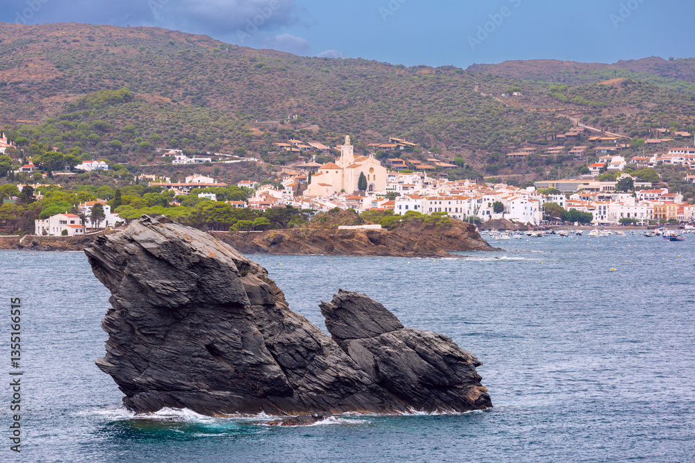 View of Cadaques bay with rocky coastline, rock formations, and a boat in Catalonia, Spain