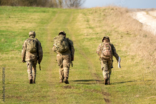 two male and a female British army infantry soldiers on a tab tabbing exercise