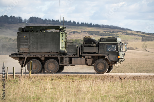 British army MAN SV HX 60 6x6 18.330 platform truck, loaded with a specialist container, in action on a military exercise