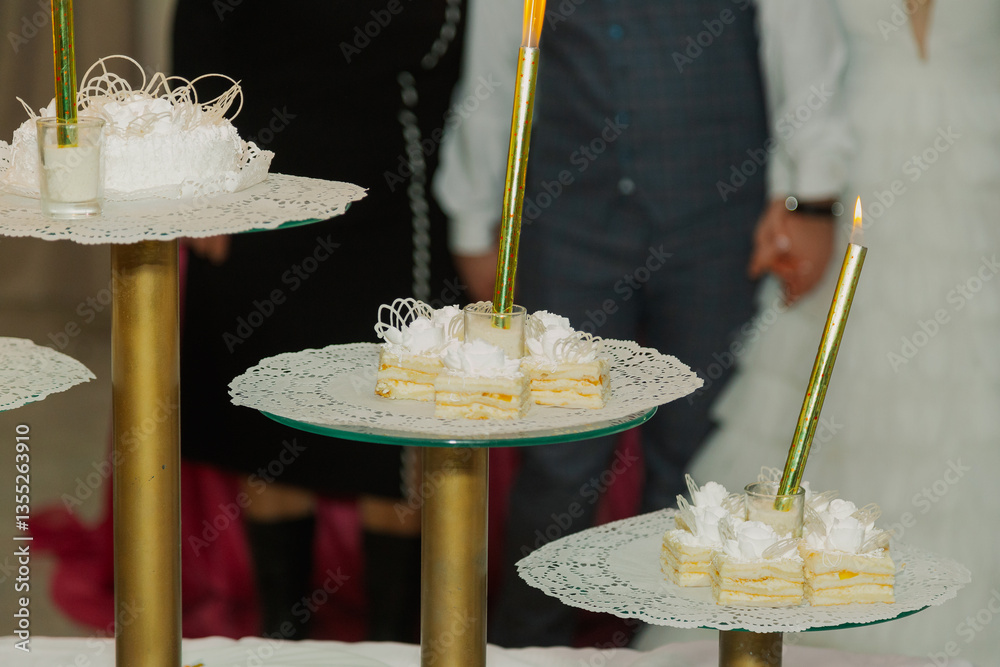 Beautiful wedding cake at a wedding with glowing lights. newlyweds in the background