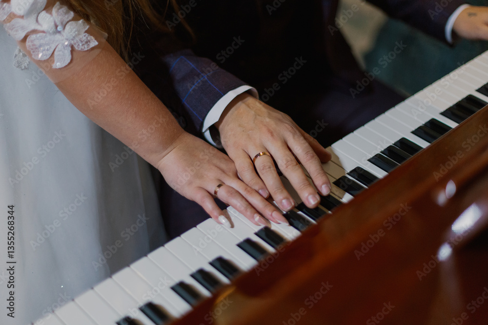 Fototapeta premium Beautiful hands with newlyweds rings on piano keys