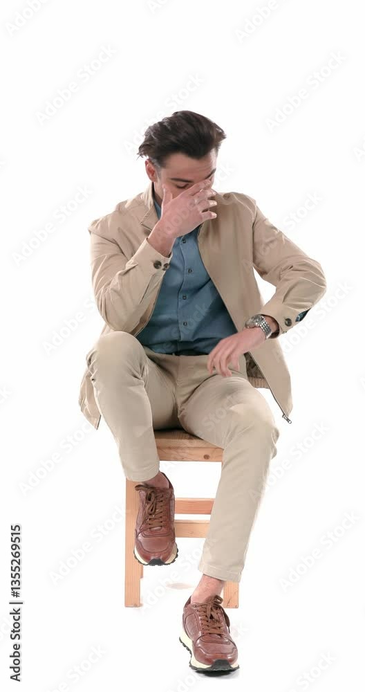 hurried handsome young man looking at the clock, switching legs up, putting head to forehead and realising he is late in front of white background hurried handsome young man looking at the clock, switching legs up, putting head to forehead and realising he is late in front of white background