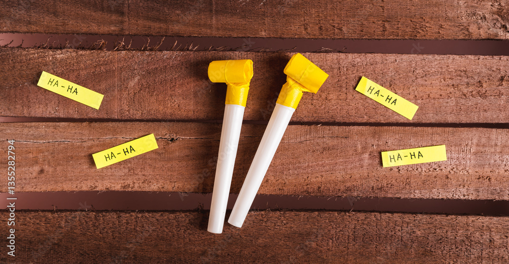 Happy April Fools Day, whistles and funny notes on wooden background top view web banner