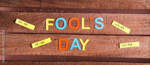Obraz na płótnie April Fools Day from colored letters, funny notes and paper on wooden top view web banner w salonie