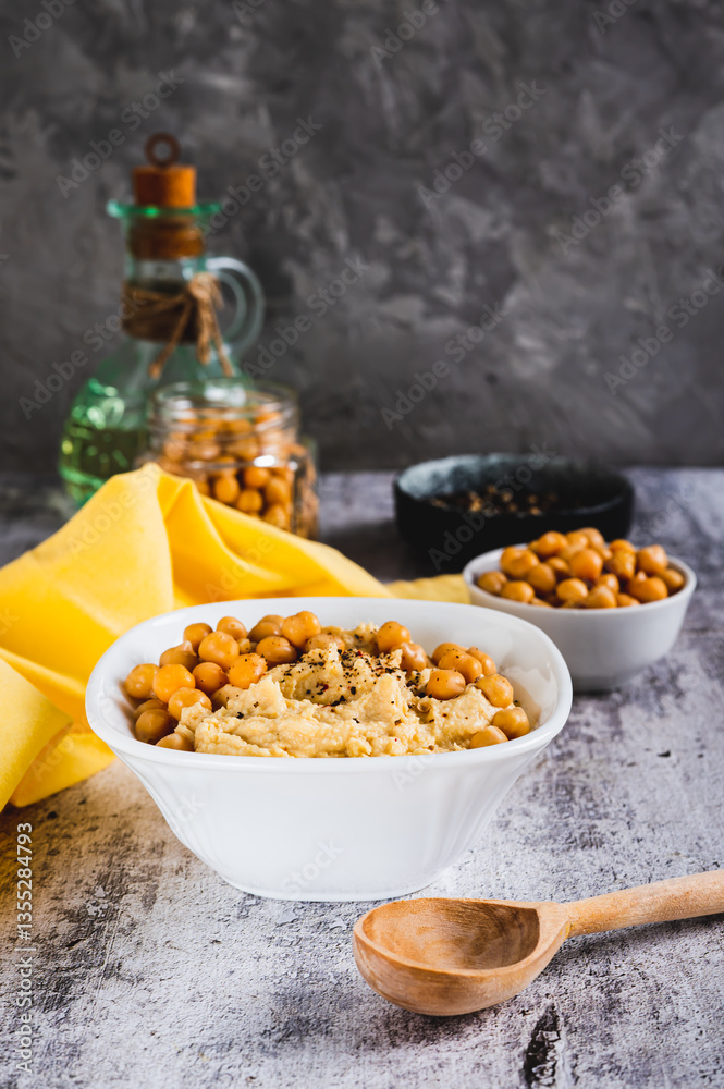 Homemade hummus with chickpeas in a bowl on the table vertical view