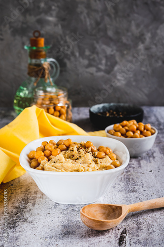 Obraz na płótnie Homemade hummus with chickpeas in a bowl on the table vertical view w salonie