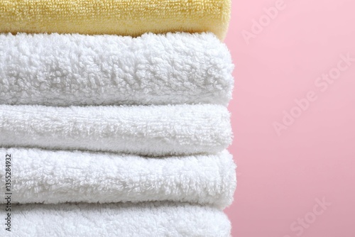 Stack of towels on color background