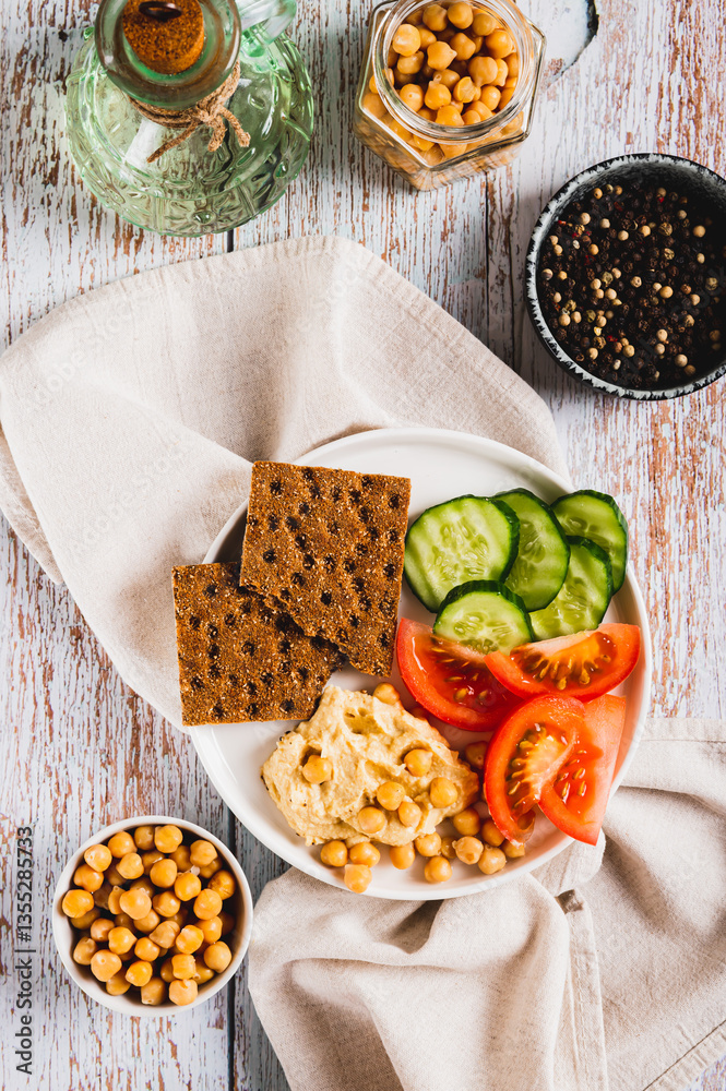 Vegetarian plate with chickpeas and vegetables on the table top and vertical view