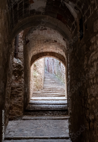 Narrow passage way with stone steps and arch, in the historic Jewish Quarter in the city of Girona in Catalonia, Spain. Jews lived and thrived in the city before the expulsion in 1492.