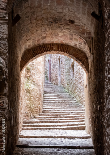 Narrow passage way with stone steps and arch, in the historic Jewish Quarter in the city of Girona in Catalonia, Spain. Jews lived and thrived in the city before the expulsion in 1492.