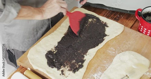 Poppy seed roll strudel preparing, stuffing dough with sweet poppy seed filling