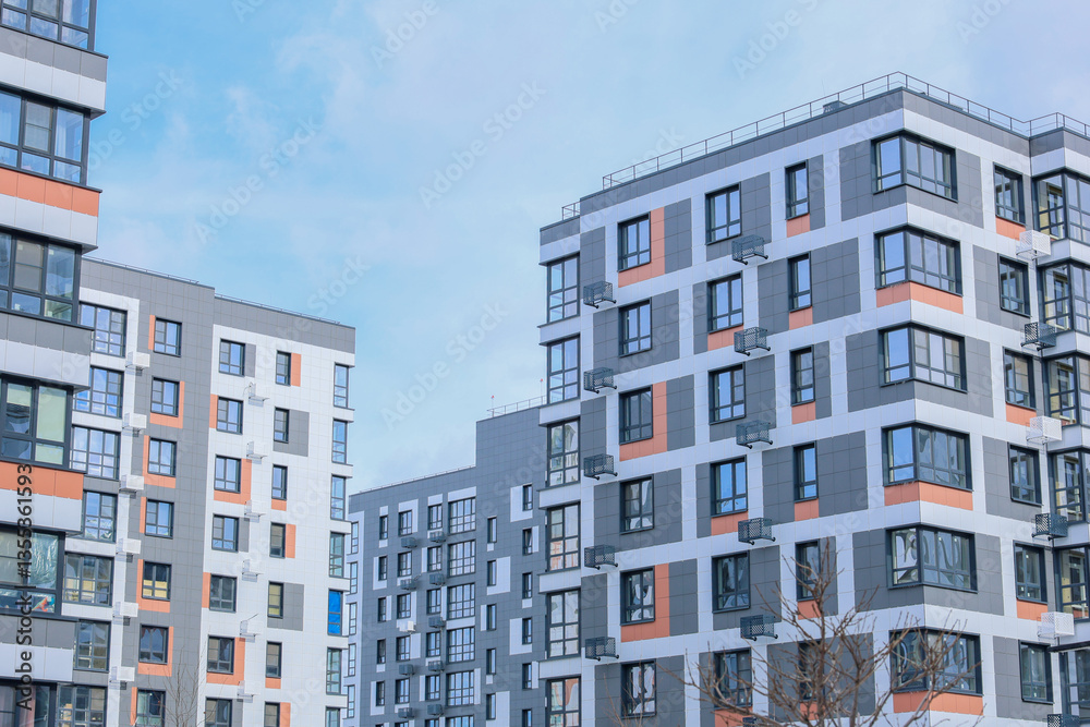 Fototapeta premium The concept of modern architecture, residential complex, apartment buildings for living. Multi-storey, apartment buildings of the residential complex in a single architecture in gray and white tones