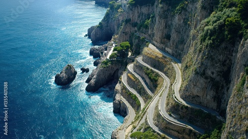 Aerial view of a winding coastal road clinging to the cliffs edge near the turquoise sea