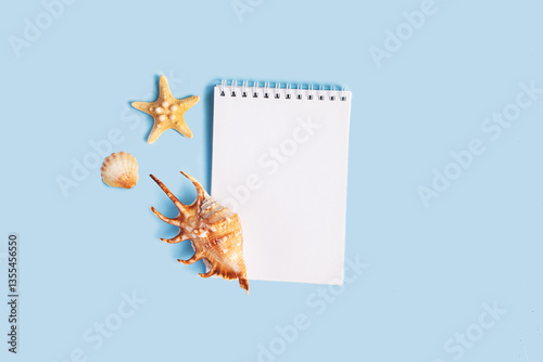 To do list or blank notebook with set of starfish, sea shell on blue background. Travel, summer vacation or weekend, packing plan. lat lay, top view, copy space, place for text, minimal composition