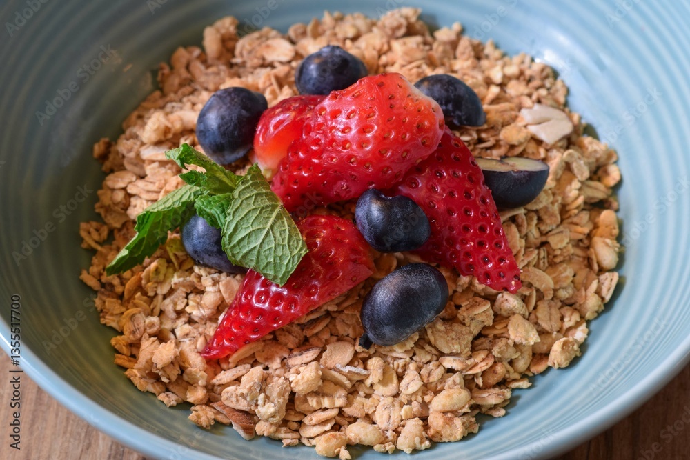 Closeup bowl of breakfast granola with fresh strawberries and blueberries Closeup bowl of breakfast granola with fresh strawberries and blueberries