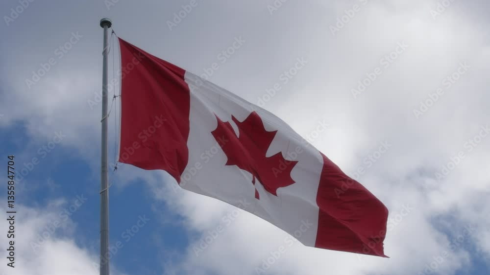 Canadian flag waving in the wind against the blue cloudy sky Canadian flag waving in the wind against the blue cloudy sky