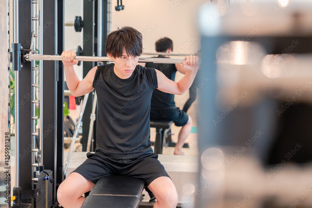 ジムで筋トレをする若い男性