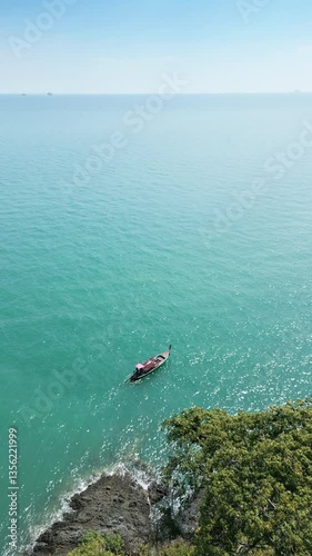 Wallpaper Mural Vertical Video Drone shot of a motorboat in a tropical paradise with coastal cliffs, stunning Thai seascape featuring a boat exploring turquoise waters near the shoreline. Exotic lagoon bay in Torontodigital.ca
