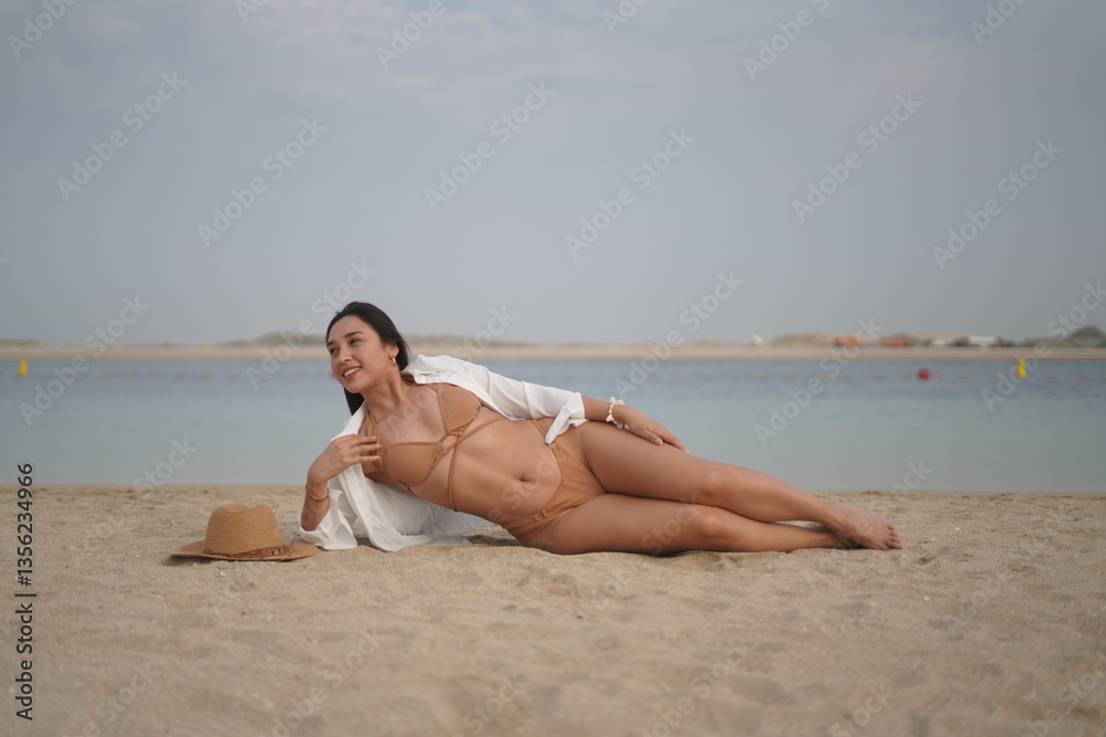 Relaxed Woman in Bikini and Hat Posing on Sandy Beach Relaxed Woman in Bikini and Hat Posing on Sandy Beach