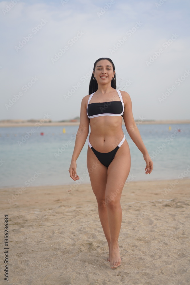 Confident Woman Posing in Bikini and Hat on a Sunny Beach Confident Woman Posing in Bikini and Hat on a Sunny Beach