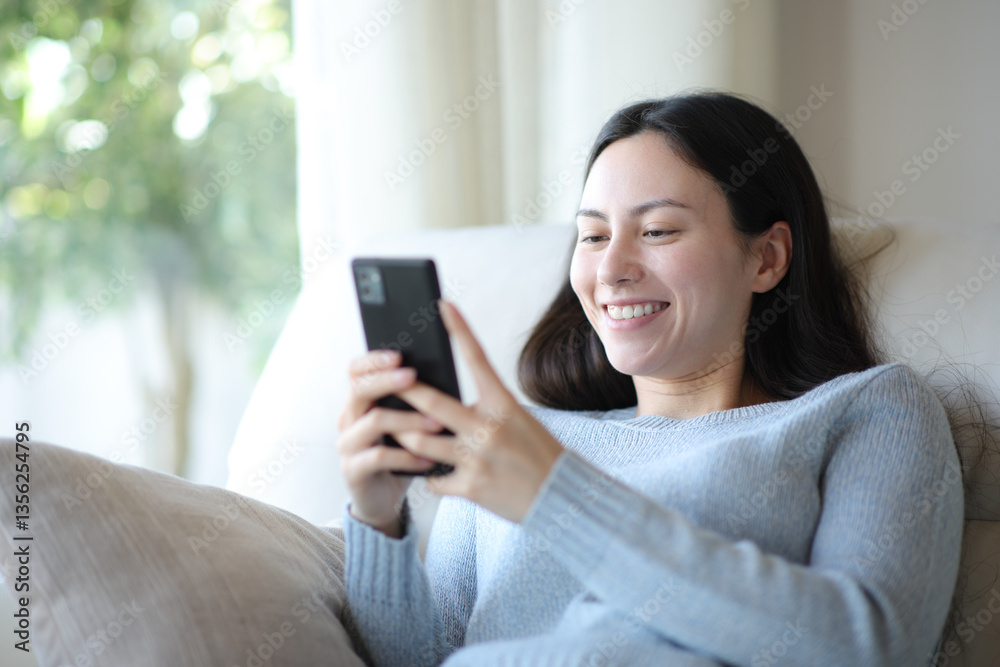 Happy asian woman is using smart phone at home Happy asian woman is using smart phone at home