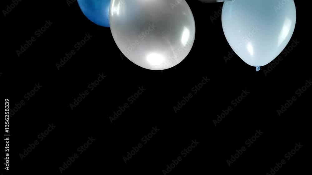 A slow-motion scene of balloons in various vibrant colors falling gracefully from top to bottom. The balloons create a playful, colorful spectacle as they descend, enhancing the joyful atmosphere.