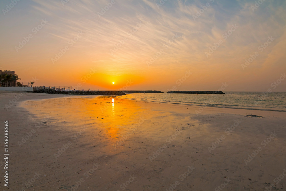 Stunning sunset on the beach with golden hues reflecting on the waves. Breathtaking view of the beautiful beach, creating a serene and coastal scene
