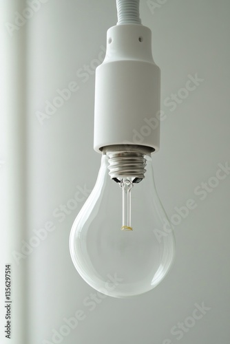 A light bulb hangs from the ceiling in a room, providing warm lighting