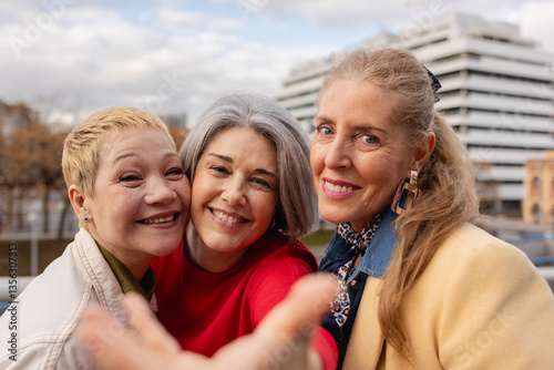 Group of mature women smiling outdoors in an urban setting photo