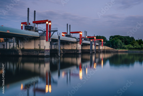 Evening view of Sperrwerk Billwerder Bucht in Hamburg, Germany with reflections on the water photo