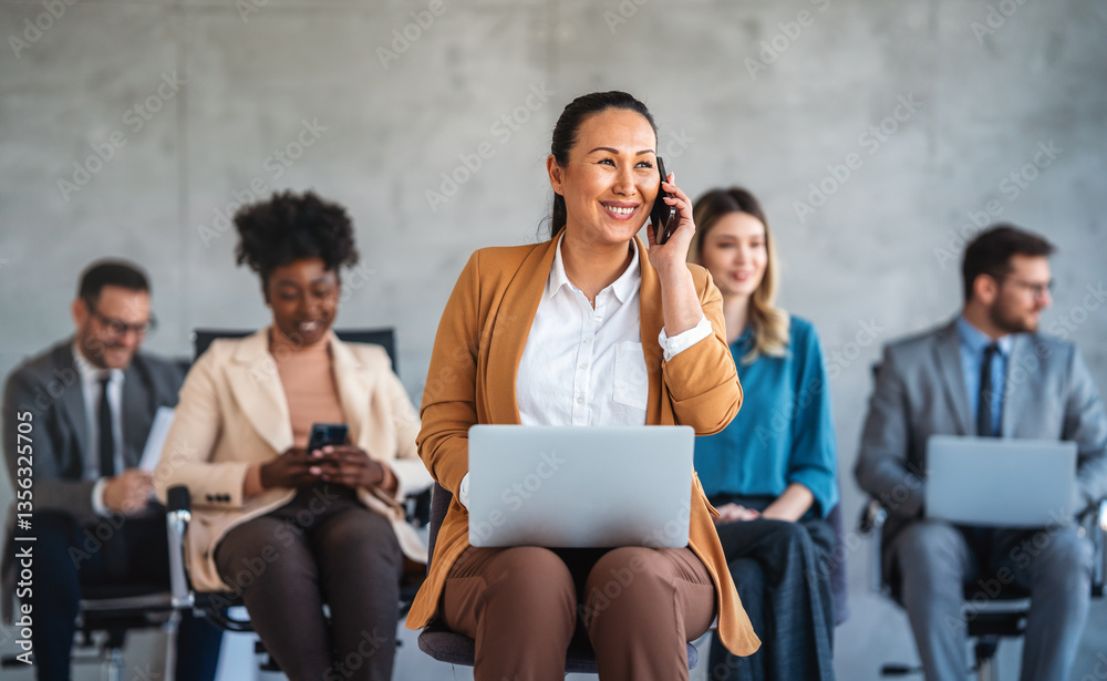 Happy businesspeople laughing while collaborating on a new project in an office.
