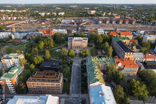 Aerial cityscape of Turku, Finland featuring the Art Museum, Puolalanpuisto park, the new Logomo Bridge, residential buildings, and the railway yard in summer light.