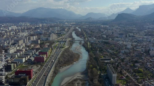 Aerial shot of the city of Grenoble surrounded by mountains with a river running through it, in France