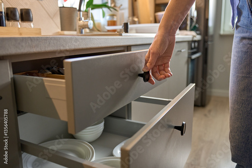 Schilderij op canvas Person opens a kitchen drawer with various utensils in wooden cutlery tray