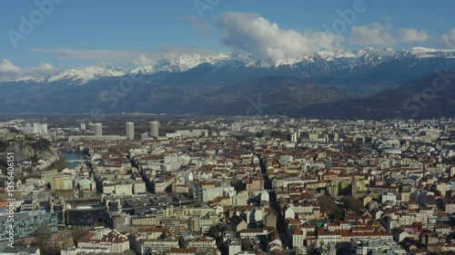 Aerial shot of the city of Grenoble surrounded by snow-capped mountains in winter, in France