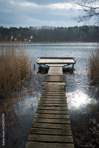 Obraz na płótnie Fishing pier on the lake, beginning of the fishing season.
w salonie