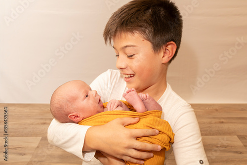 Older brother holding newborn sibling