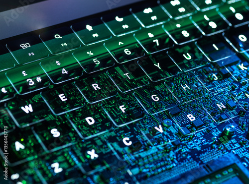 Illuminated laptop keyboard with visible circuit board representing cybersecurity and AI