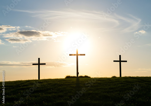 Three crosses are silhouetted on a grassy hill under a golden sunset sky, representing faith and hope.
