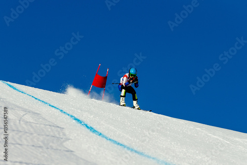 Obraz na plátně skier passes red gate down snow-covered slope during competitive downhill skiing
