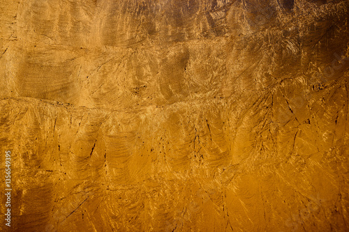 Surface showcases a golden texture with variations, reflecting soft light and inviting detail exploration.