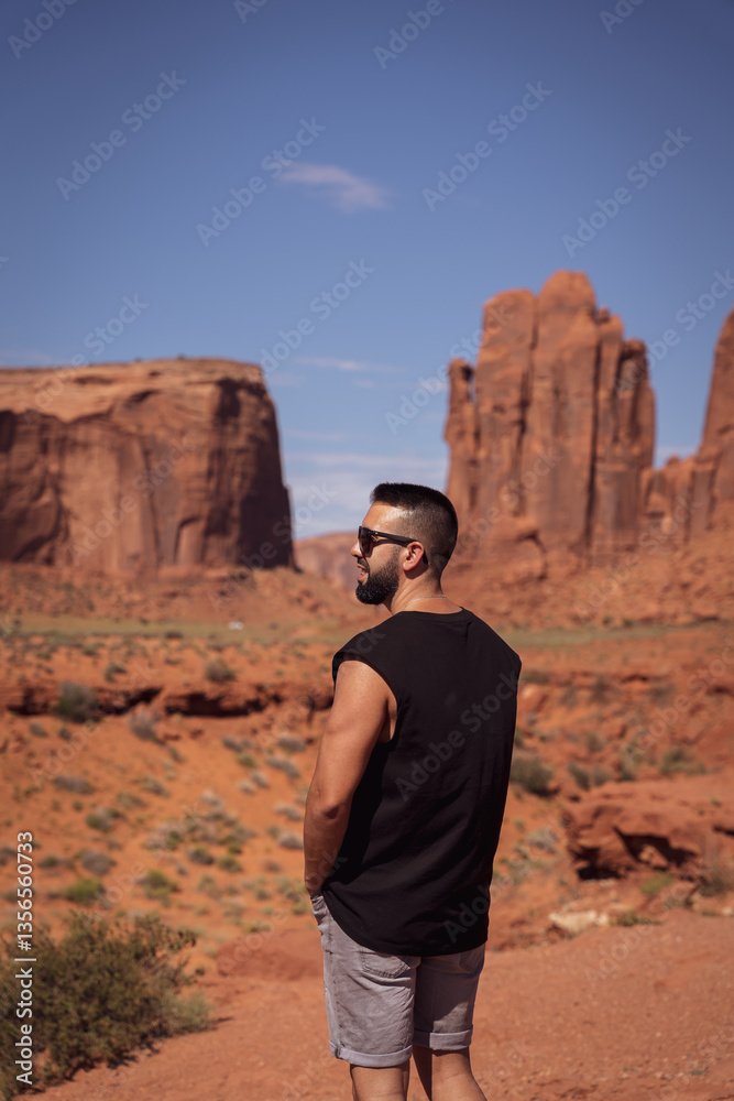 Young male tourist with the breathtaking scenery of Monument Valley Young male tourist with the breathtaking scenery of Monument Valley